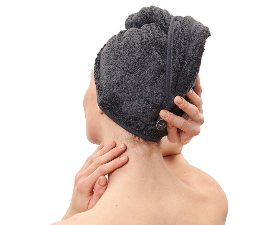 Žena si upravuje antracitový uterákový turban na hlave.