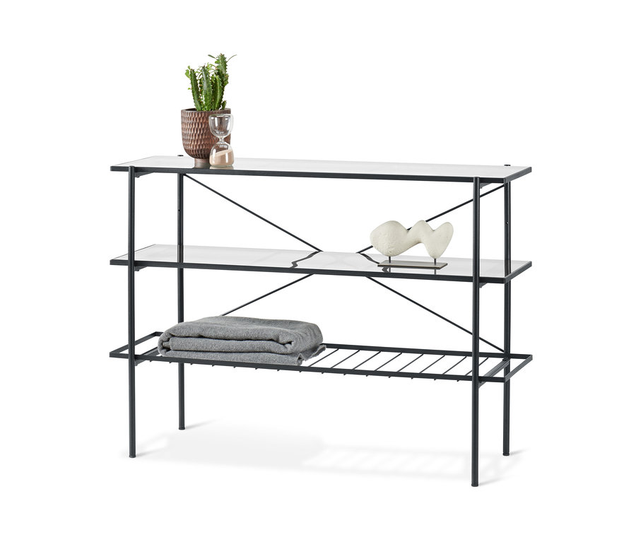 Konzolový stolík šírky cca 120 cm s tromi policami. Na hornej polici je kvetináč, sklenené hodiny a na druhej polici je dekorácia.