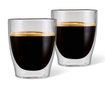 Dva dvojstenné poháre na espresso plné kávy.