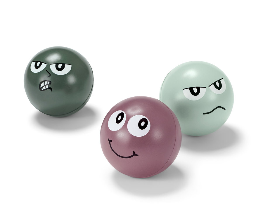 Tri antistresové loptičky s tvárami. Jedna je zelená s nahnevaným výrazom, druhá fialová s usmiatym výrazom a tretia svetlozelená s otráveným výrazom.