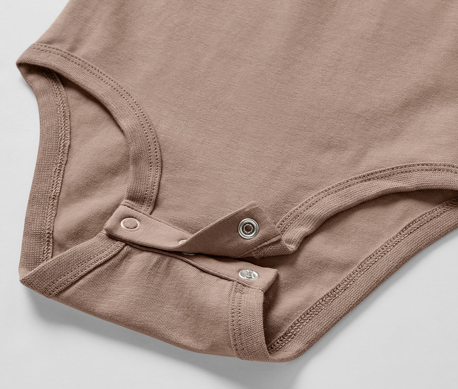 Detail hnedého body pre bábätko zo Súpravy pre bábätko, so zapínaním na patentky.