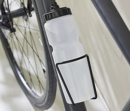 Detail bicykla s držiakom na fľašu vrátane fľaše.