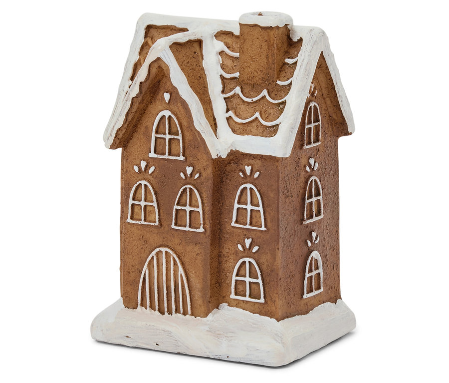 Detailný záber na hnedý perníkový domček s bielou polevou na okne a streche.