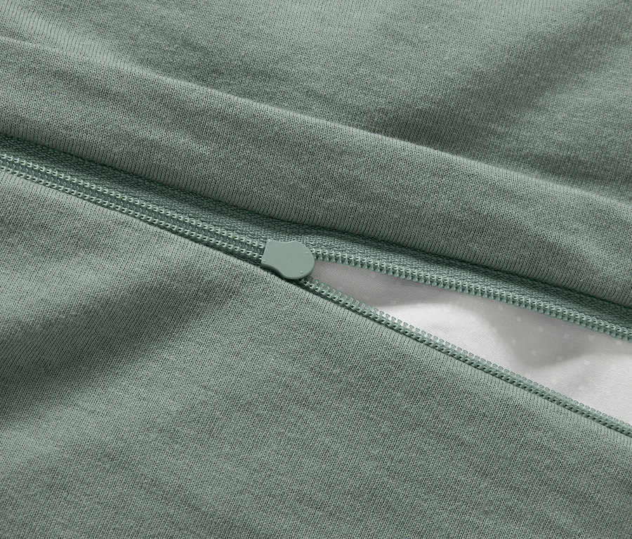 Detail zelenej obliečky so zipsom.