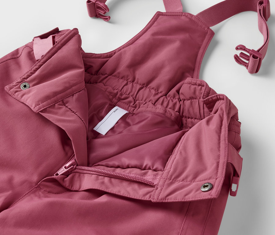 Detailný záber na rozopnutú detskú zimnú kombinézu 2-dielnej súpravy v ružovej farbe.
