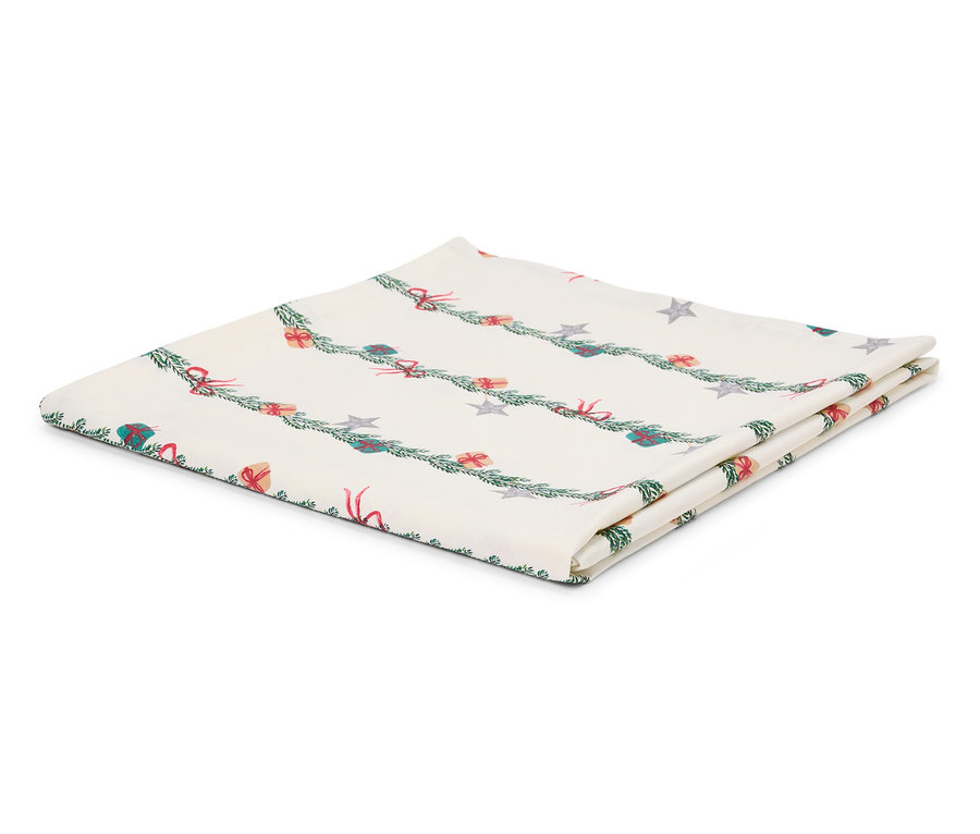 Zložený biely obrus s vianočným motívom vetvičiek, darčekov a hviezd.