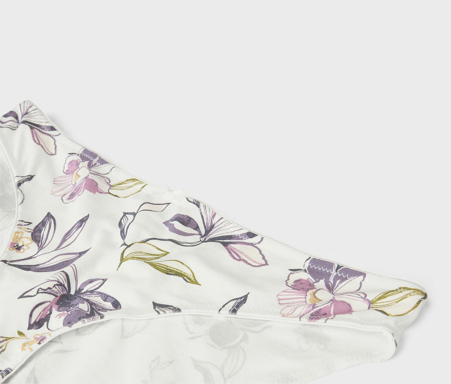 Detail bielej spodnej bielizne s kvetinovým vzorom.