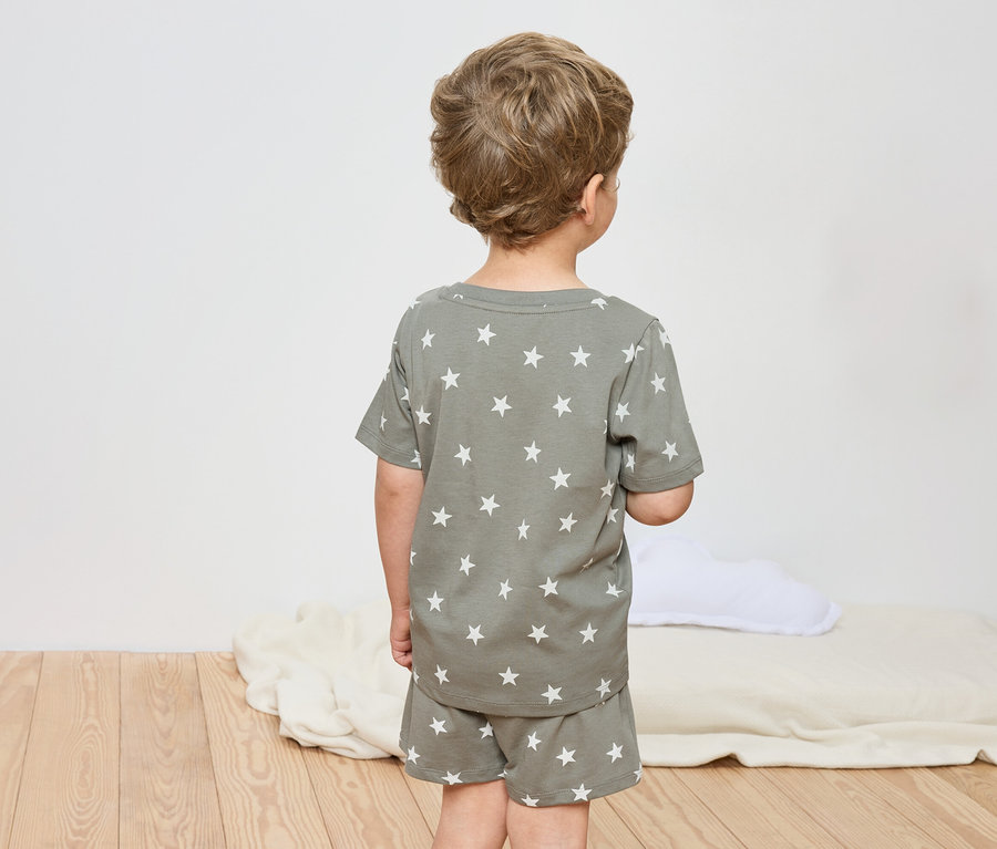 Dieťa zozadu, oblečené v pyžame s hviezdami.