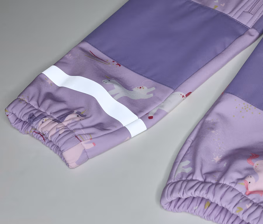 Detail fialových detských nohavíc so vzorom jednorožca a reflexným prúžkom na rukáve.