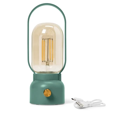 Zelená lampa so žltou sklenenou bankou stojí vedľa bieleho USB kábla.
