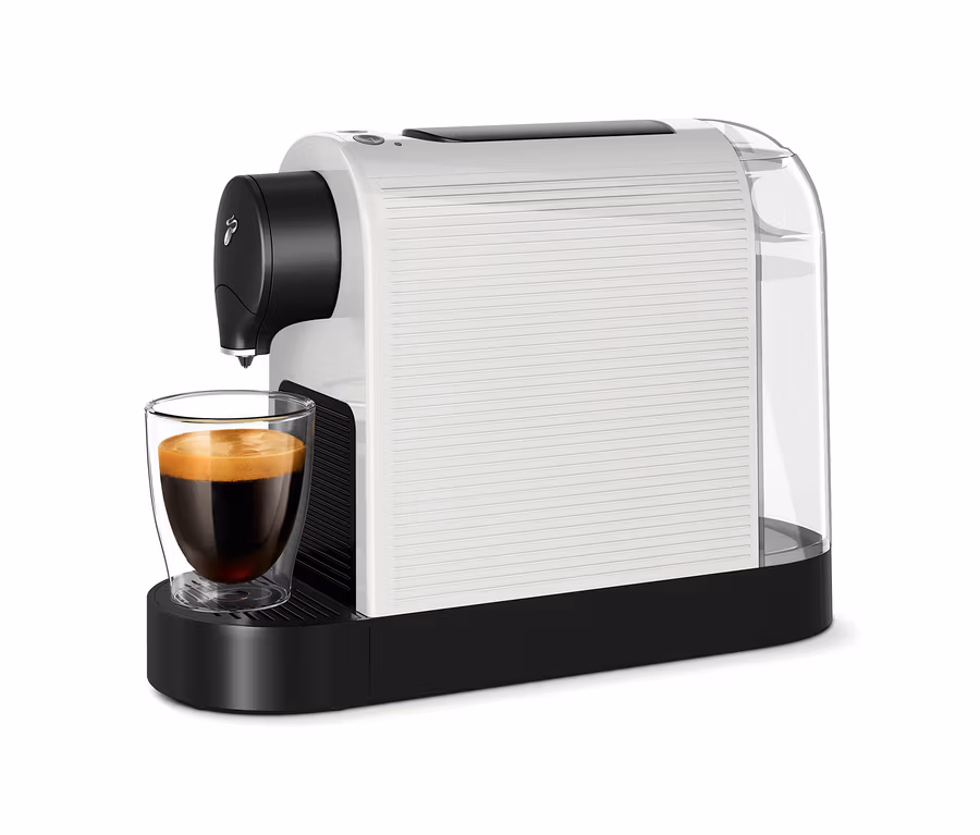 Biely kávovar Cafissimo pure+ plní sklenený pohár kávou.