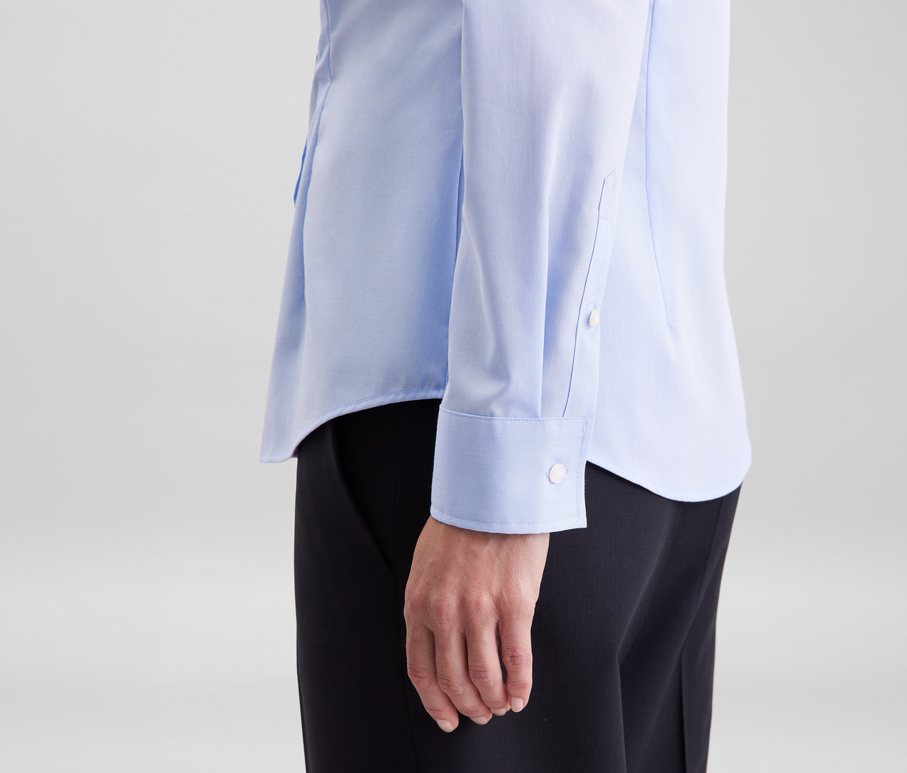 Osoba v svetlomodrej blúzke Seidensticker Slim Fit non iron a čiernych nohaviciach.