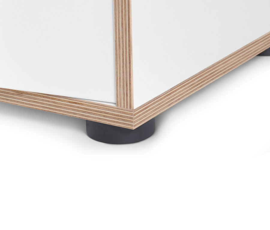 Detailný pohľad na spodnú časť bieleho sideboardu s dvierkami, s dreveným lemovaním a čiernymi nožičkami.