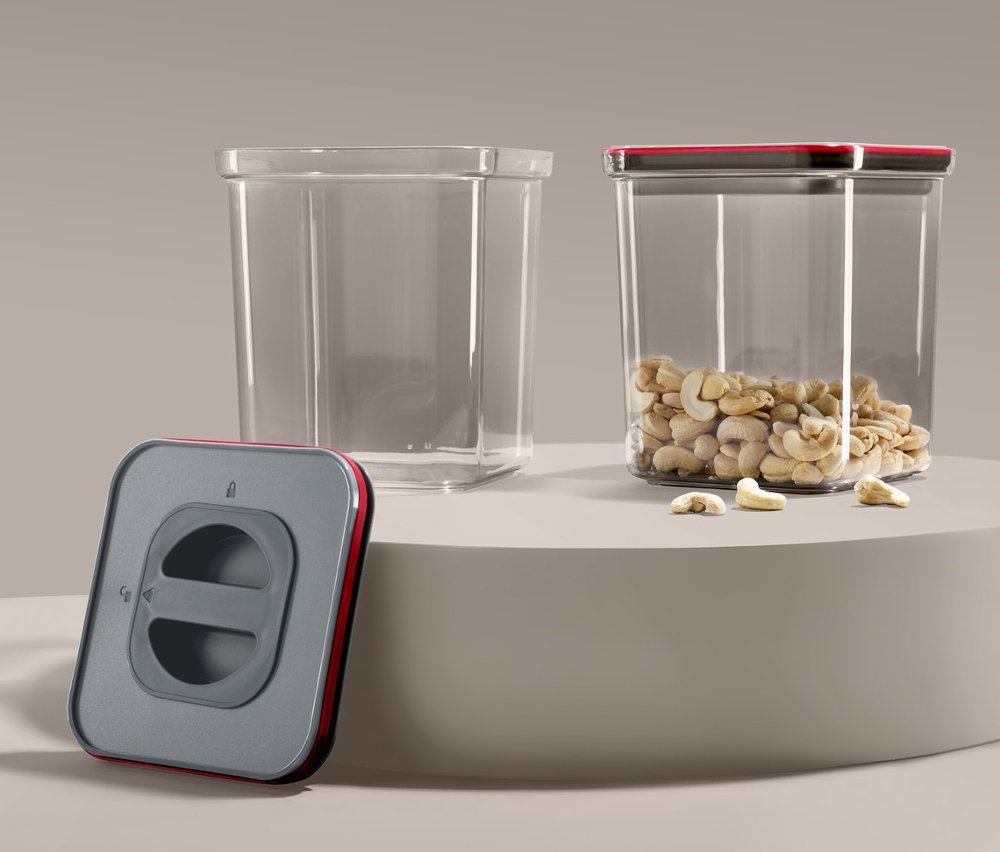Dve vákuové dózy na potraviny, jedna prázdna a jedna plná kešu orieškov, a vákuová pumpa.