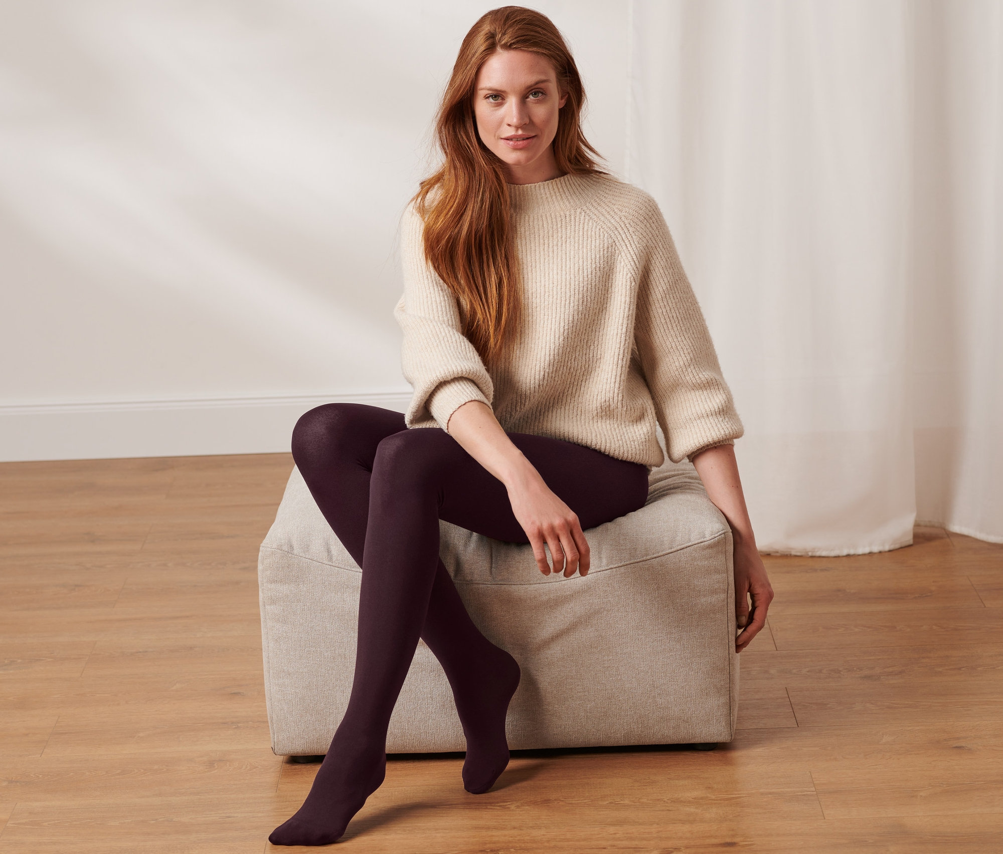 Žena sedí na taburete a má na sebe termopančuchy.