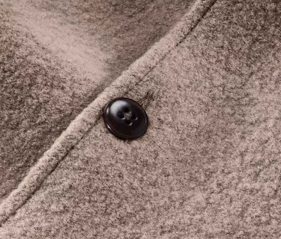 Detail hnedého detského vychádzkového overalu s vlnou merino a gombíkom.