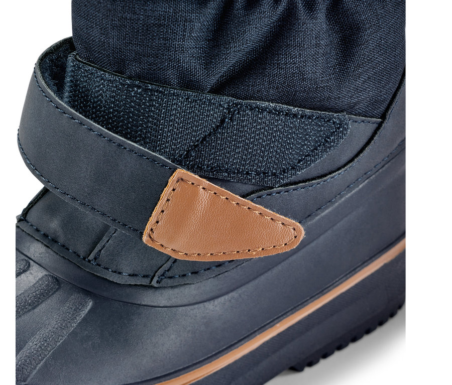 Detail detskej vysokej topánky do každého počasia, modrá topánka so suchým zipsom a hnedým koženým detailom.