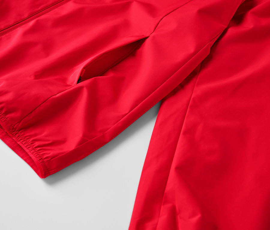 Detail červenej vetruvzdornej funkčnej bundy.