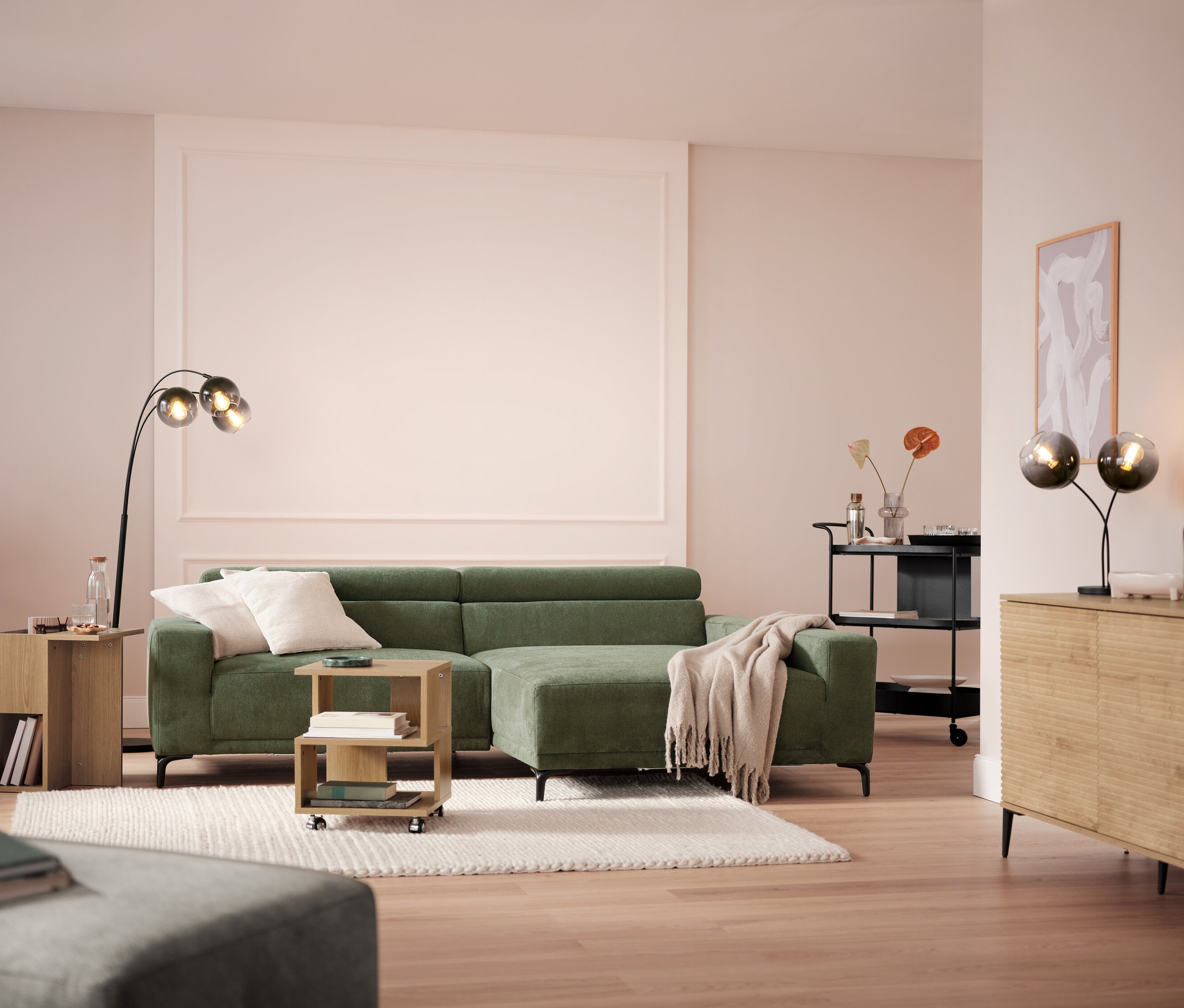 Obývacia izba s pohovkou, lampou a servírovacím vozíkom.