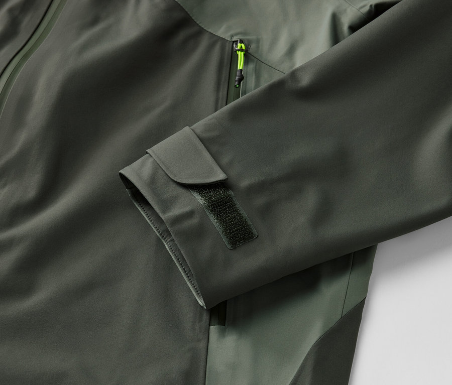 Detail khaki 3-vrstvovej outdoorovej bundy so zipsom a lemom na rukáve.