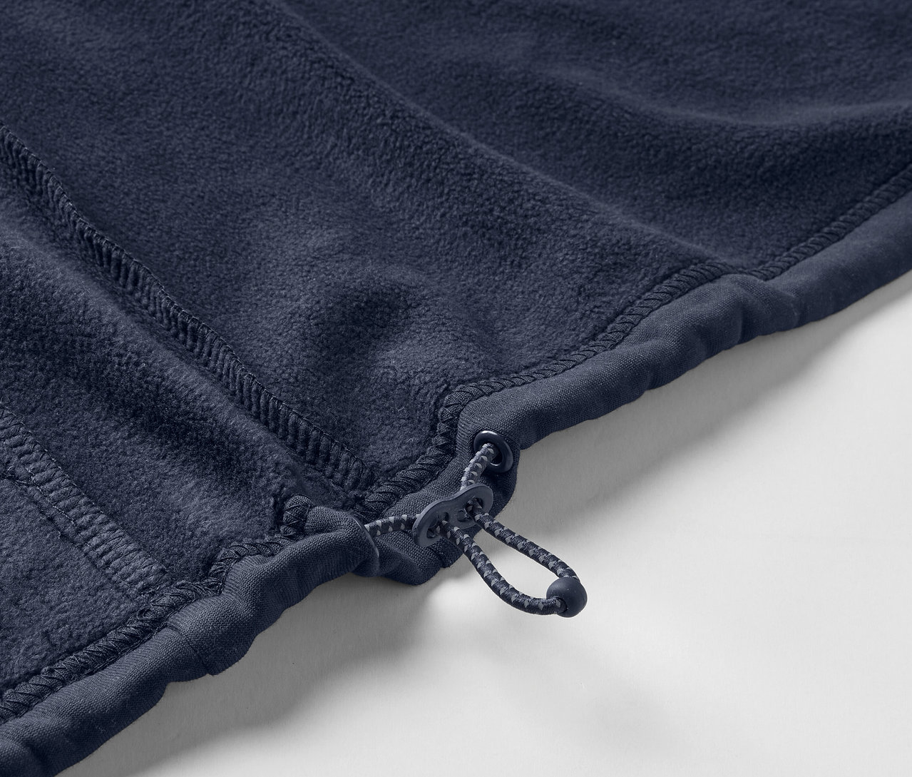 Detail modrej fleecovej bundy so zipsom.