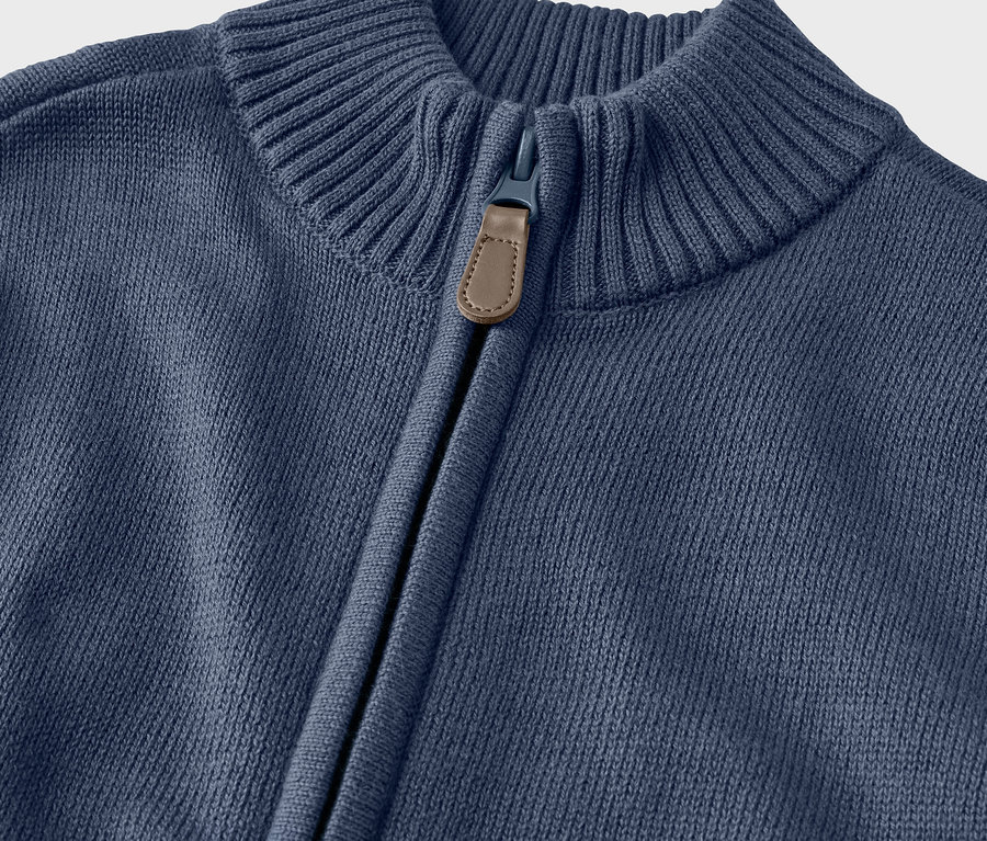 Detail detského pleteného svetra s golierom a zipsom.