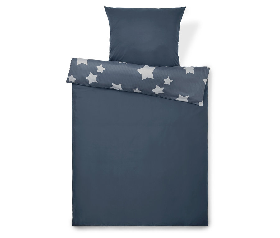 Modrá posteľná bielizeň s hviezdami a vankúšom.