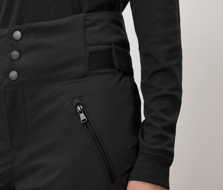 Čierne nohavice s vysokým pásom, zapínaním na tri gombíky a vreckom na zips.