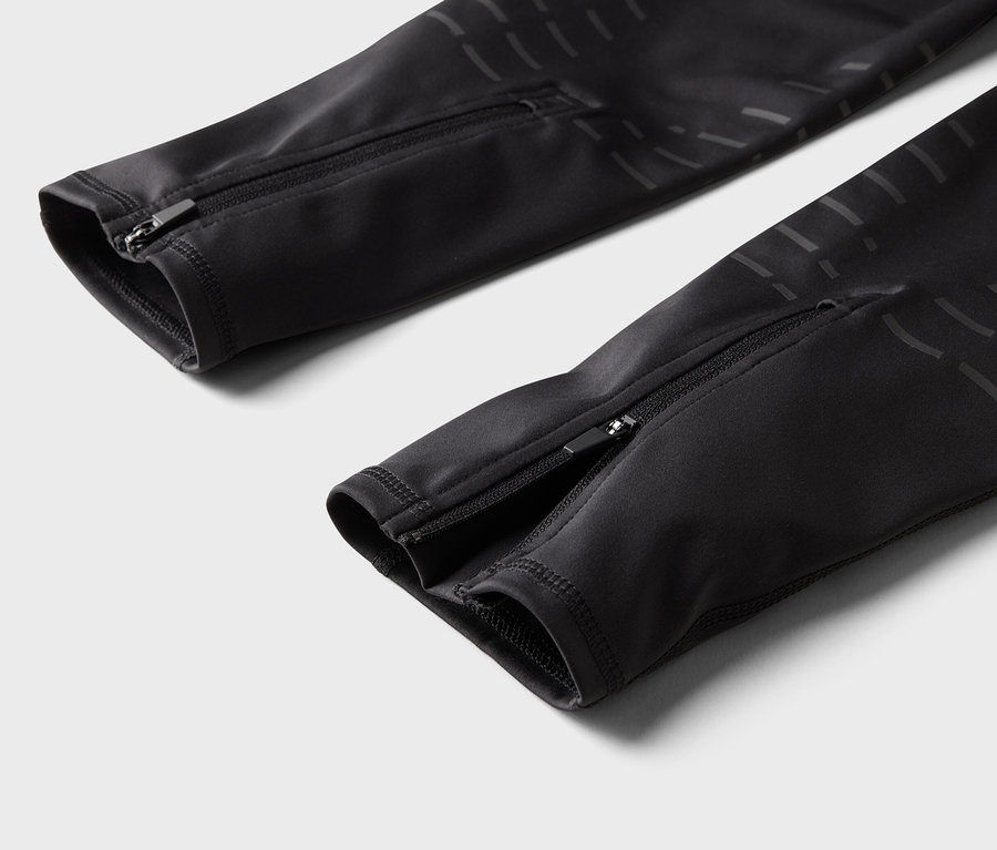 Detail čiernych nohavíc so zipsami na nohaviciach.