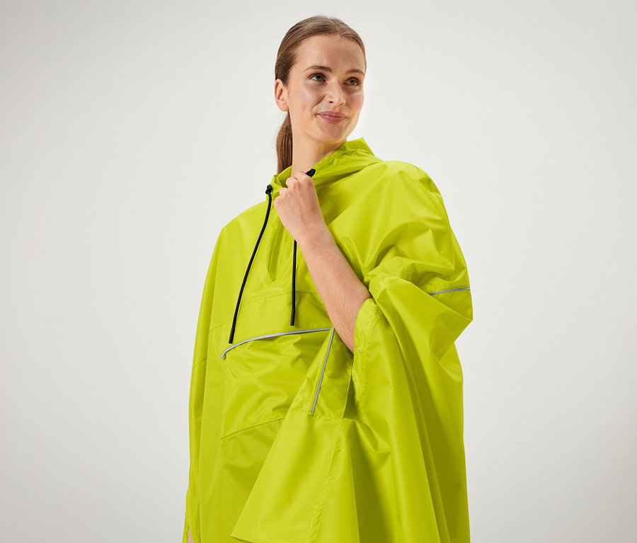 Žena si drží golier neónovo zeleného ponča.