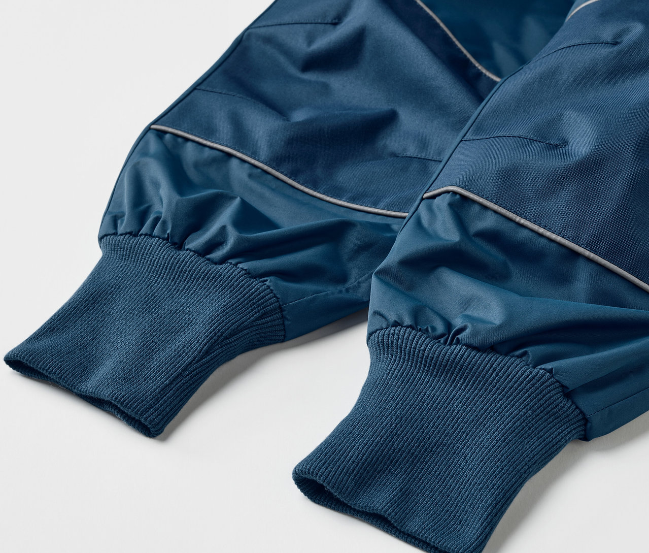 Detail detských nohavíc do dažďa v modrej farbe, ktoré rastú s dieťatkom.