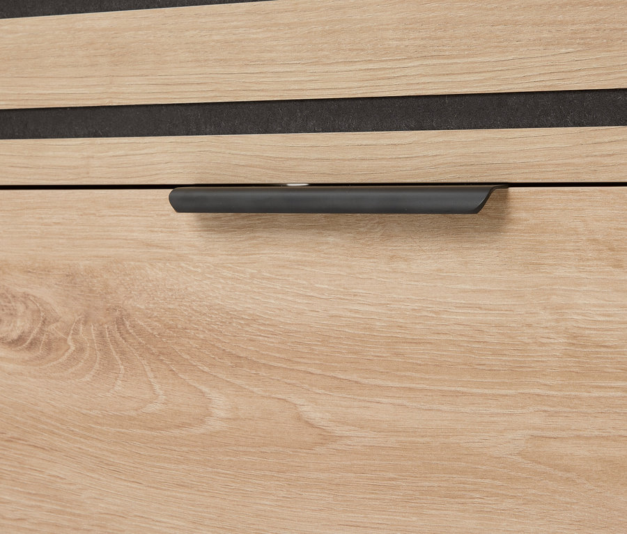 Detail zásuvky s drevenou kresbou a sivou rukoväťou.