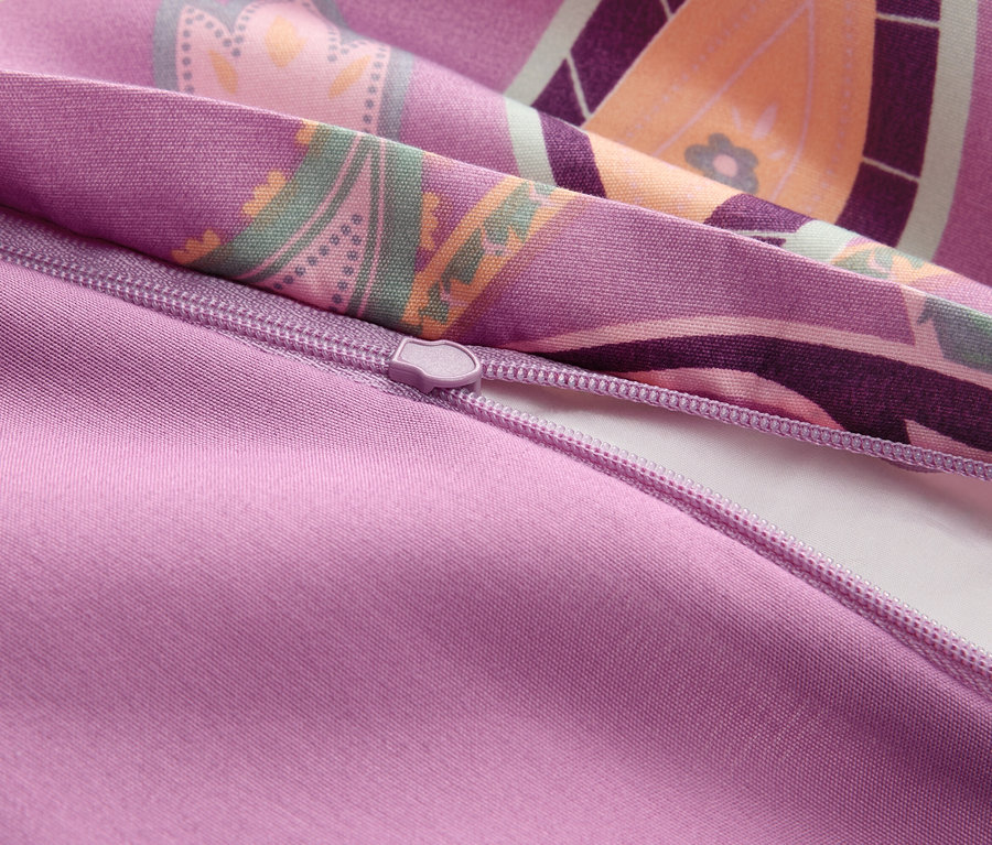 Detailný záber čiastočne otvorenej obliečky na prikrývku so zipsom vo fialovej farbe s kvetinovým vzorom.