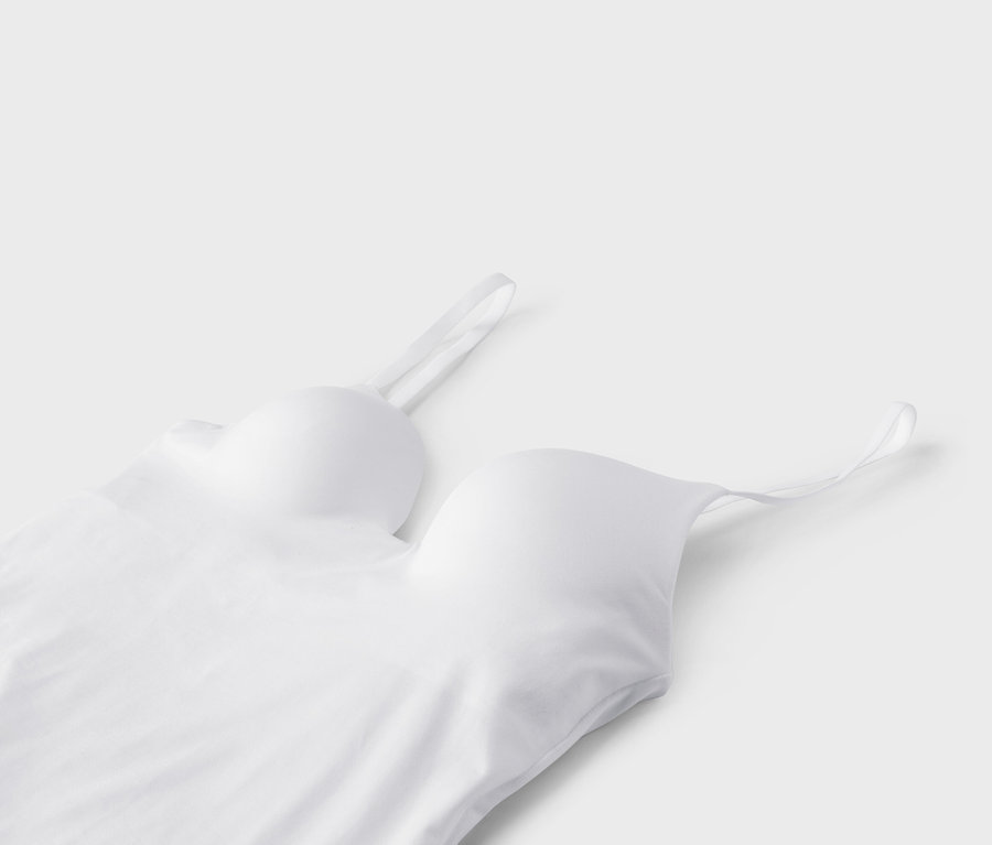 Detailný pohľad na biely bralet s tenkými ramienkami na bielom pozadí.