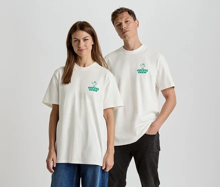 Žena a muž stoja vedľa seba a majú na sebe zodpovedajúce tričká s nápisom "Coffee Crew".