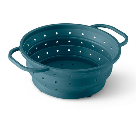 Detailný záber na priestorovo úsporné silikónové sitko v tyrkysovej farbe s rúčkami po stranách.