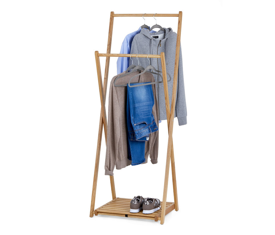Sklápací stojan na šaty z dreveného masívu s košeľou, mikinou, svetrom a džínsami na vešiakoch. Na spodnej poličke stoja topánky.