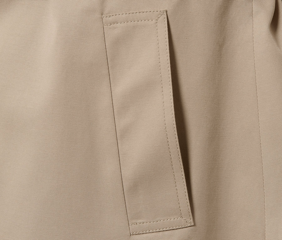 Detail béžového trenčkótu s vreckom.