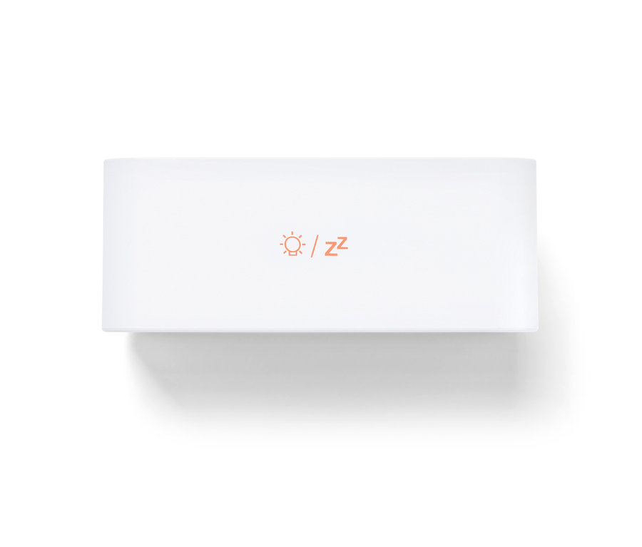 Biely digitálny LCD budík s ikonou slnka a písmenami Z v oranžovej farbe.