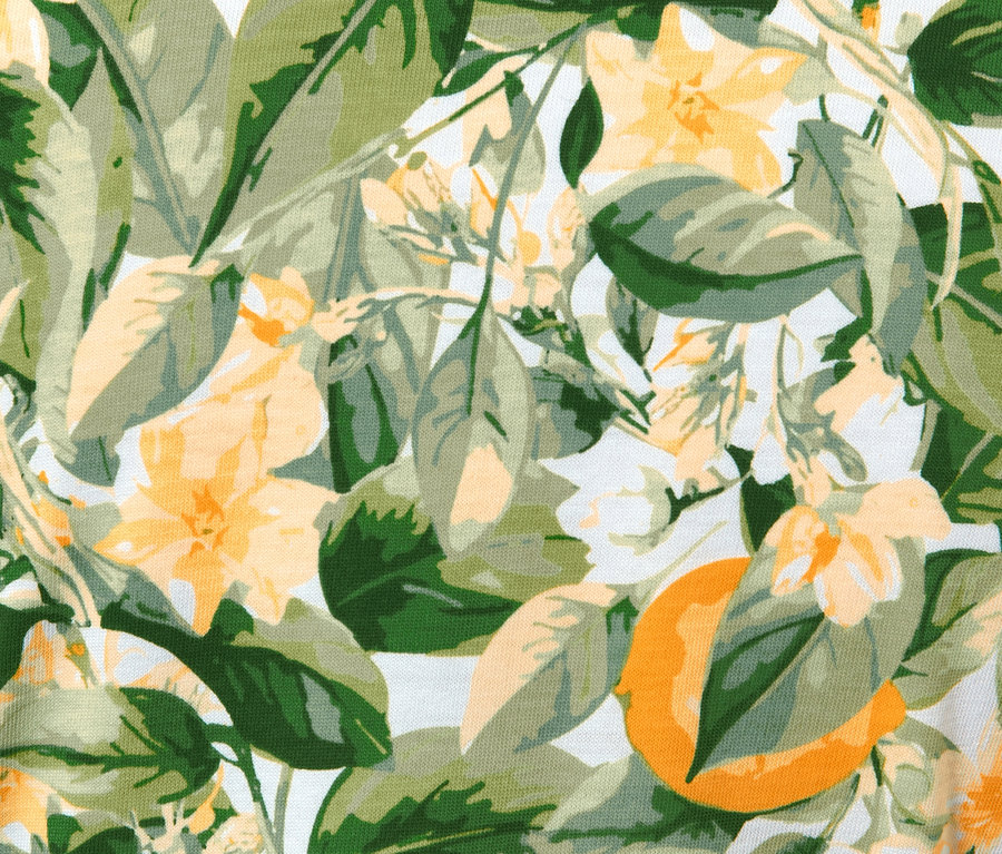 Detail látky s potlačou džersejových šiat s motívom listov a kvetov.