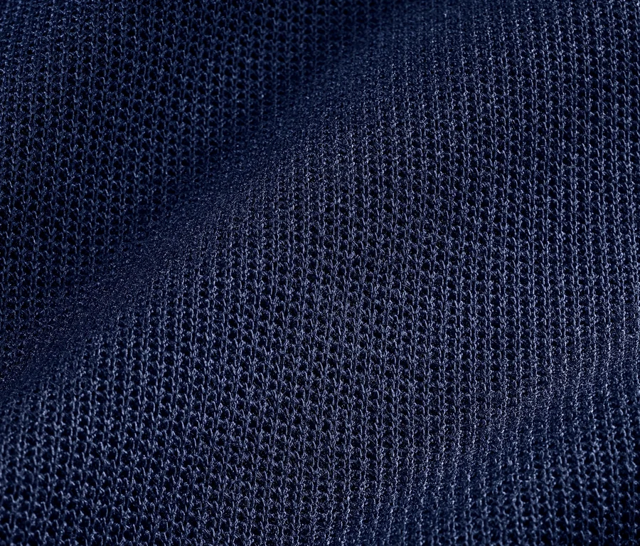 Detailný záber na štruktúrovanú, tmavomodrú látku trička.