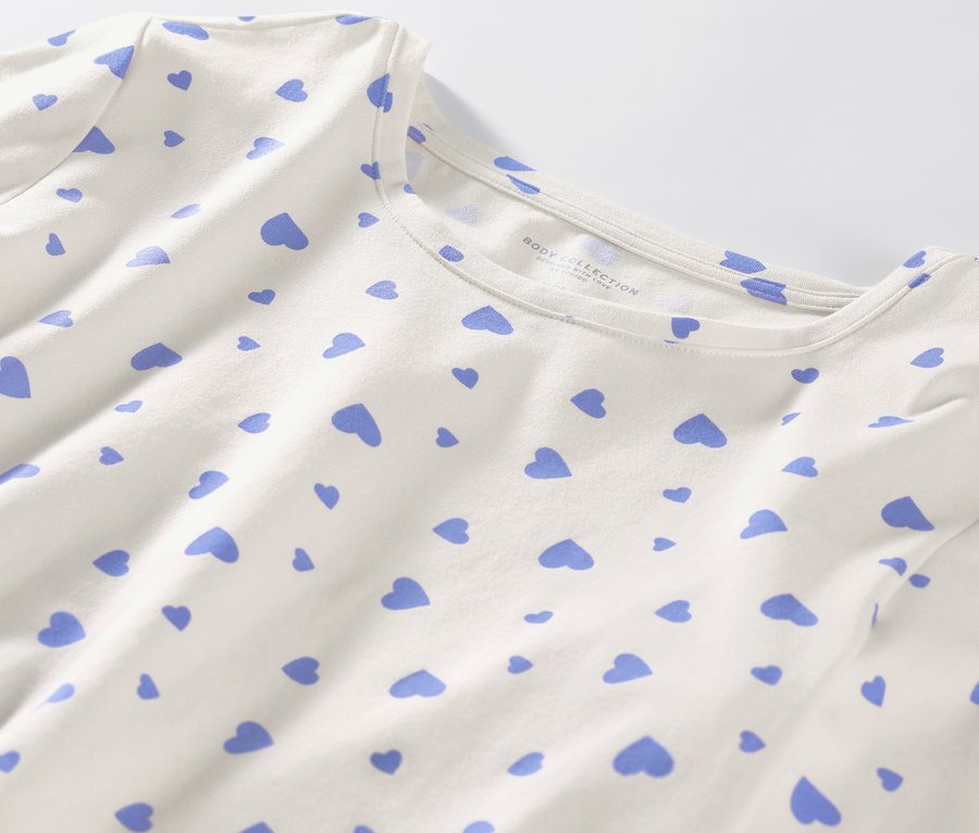 Detail bieleho pyžama so svetlomodrými srdiečkami.