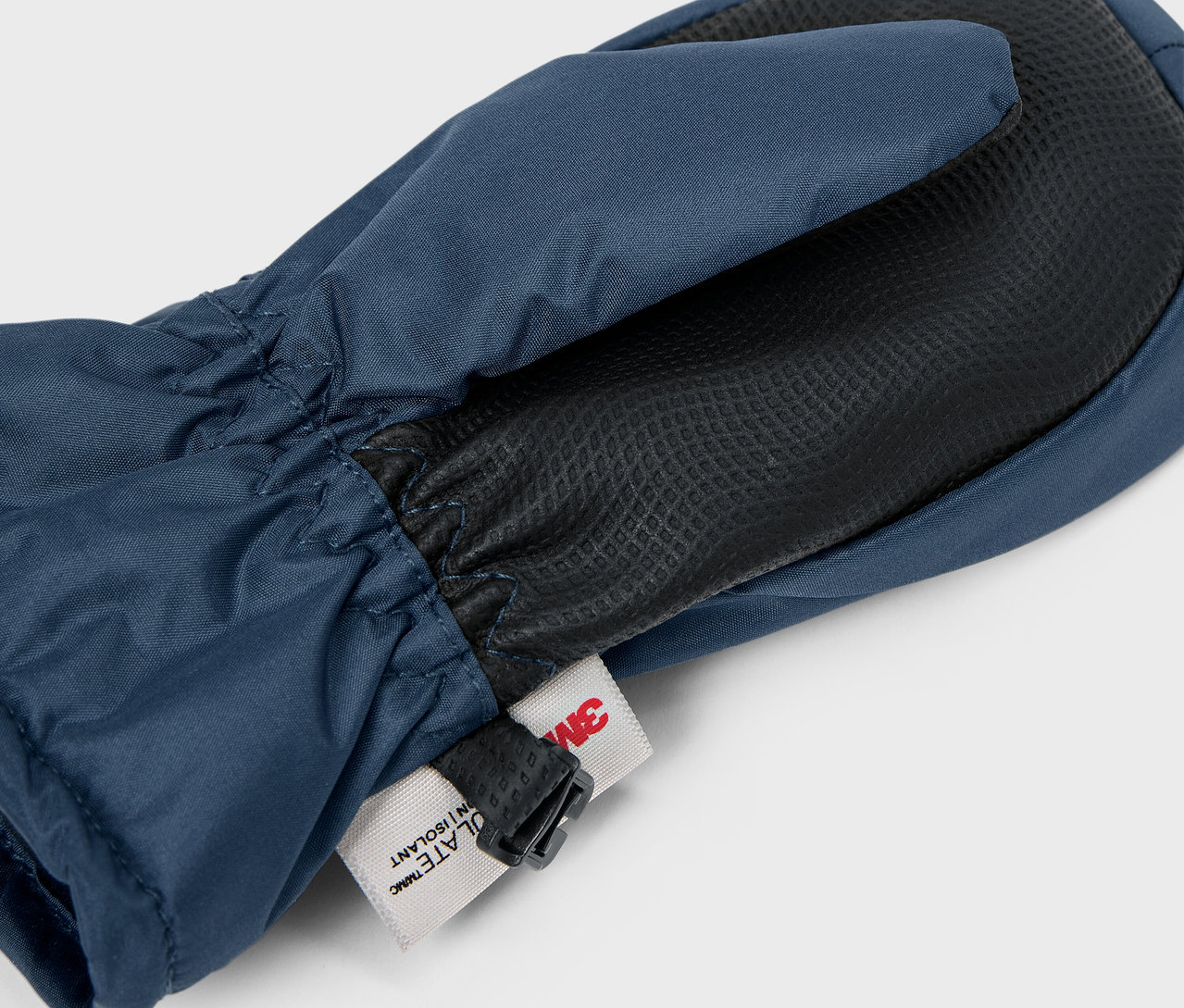 Detail modrej palčiakovej rukavice s čiernou dlaňou a štítkom 3M.