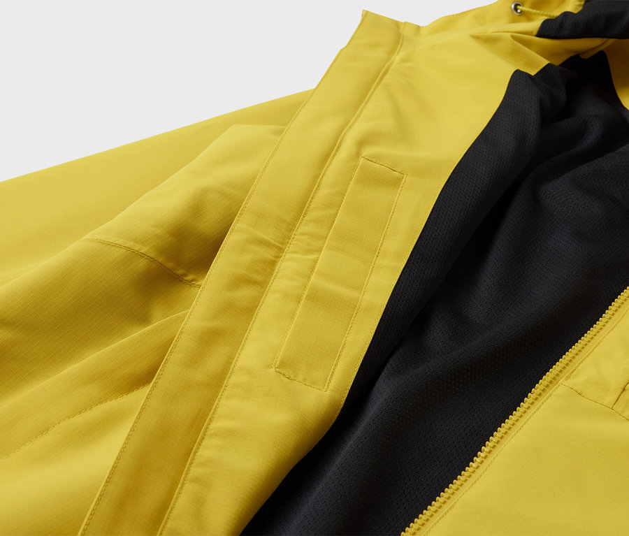 Žltá bunda s čiernou podšívkou a zipsom.