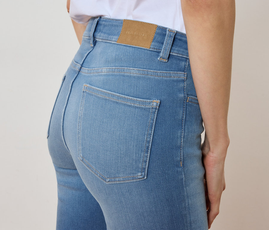 Detailný záber na ženu v svetlomodrých džínsoch.