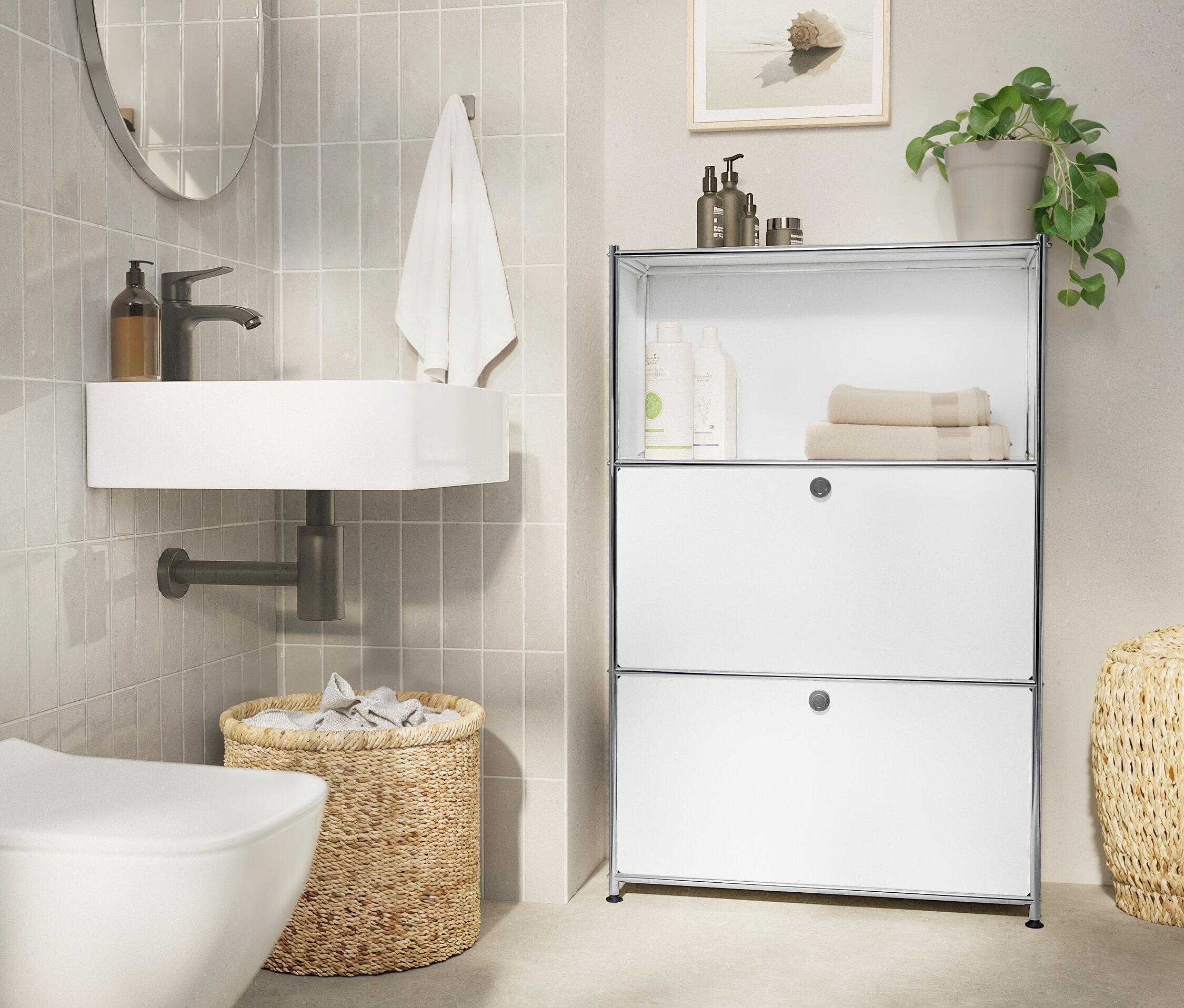 Kúpeľňa s bielym umývadlom, oválnym zrkadlom, uterákom, pleteným košom a bielym regálom.