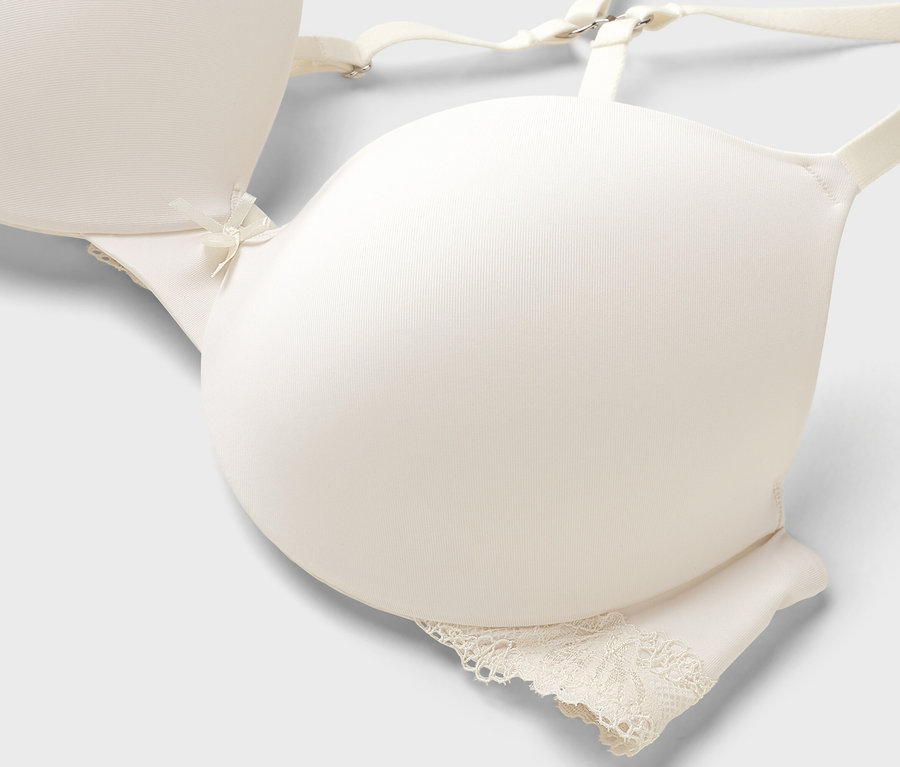 Detailný záber slonovinovej podprsenky s čipkou v spodnej časti.