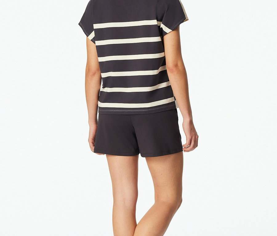 Žena zozadu v sivo-bielom pruhovanom tričku a šortkách.