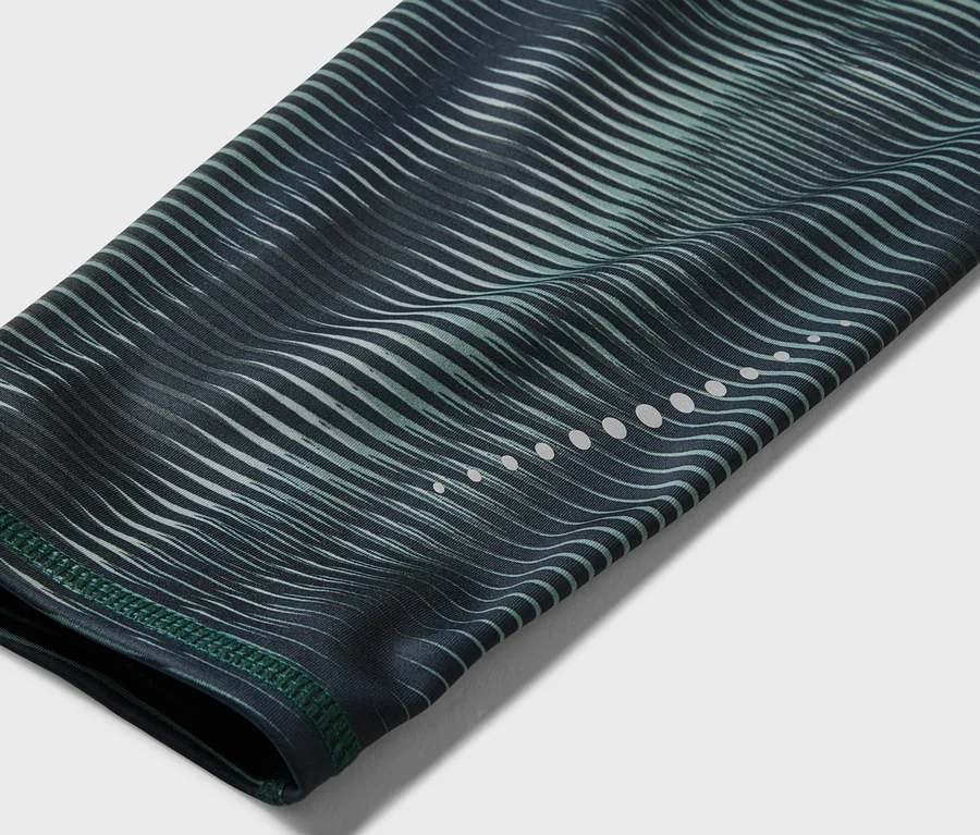 Detailný záber rukáva s vlnitým, zeleno-čiernym vzorom a reflexnými bodkami.