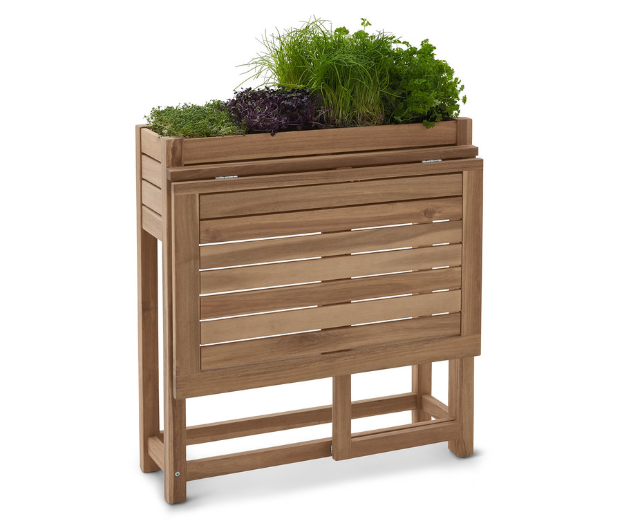 Drevený vyvýšený záhon s rôznymi bylinkami.